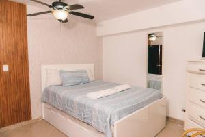 um quarto com uma cama e uma ventoinha de tecto em Beachfront 3Bedroom with Pool em Santo Domingo