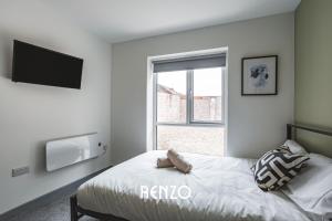 a bedroom with a bed with a television and a window at Vibrant and Inviting 1 Bed Apartment in Derby by Renzo, Perfect Hotel Alternative in Derby