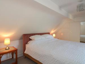 a bedroom with a white bed and two lamps at The Old Bakehouse in Oakham