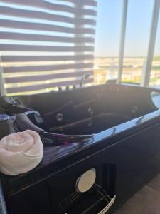 a bath tub with a towel in a room with a window at Living in Casoria