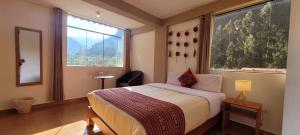 a bedroom with a bed and a large window at Ayllu B&B Ollantaytambo in Ollantaytambo