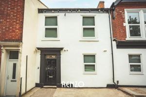 a white house with a black door and windows at Vibrant 1-bed Apartment in Derby by Renzo, Central Location! in Derby