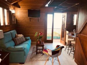 a living room with a blue couch and a kitchen at Cozy Mountain Chalet in La Orotava