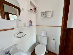 a bathroom with a toilet and a sink and a mirror at CasaLola - Corme Porto in A Coruña