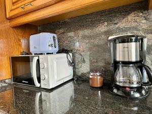 um balcão de cozinha com comodidades para preparar café e um micro-ondas em CasaLola - Corme Porto em La Coruña