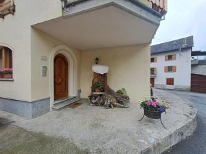 a tree stump sitting in the corner of a house at B&B La vecchia posta in Antronapiana