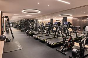 a gym with a row of treadms and machines at Bulgari Hotel Milano in Milan