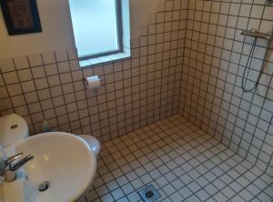 uma casa de banho com um lavatório e um chuveiro com uma janela em Ocean Winds em Wexford