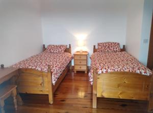 um quarto com 2 camas e uma mesa com um candeeiro em Ocean Winds em Wexford