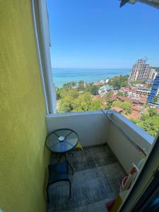 balcón con mesa y vistas al océano en Квартира у моря Колхида en Makhinjauri