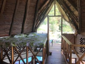 Bett in einem Zimmer mit einem großen Fenster in der Unterkunft Villa Coco in Taganga