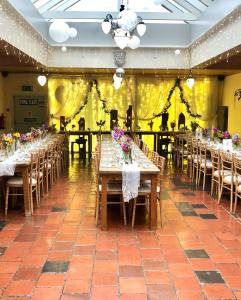 a room with long tables and chairs with flowers on them at Dufferin Coaching Inn in Killyleagh