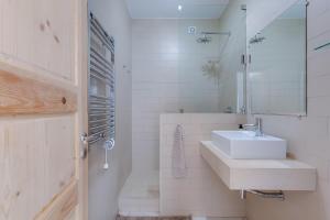 a white bathroom with a sink and a mirror at Casa Alma - V027 in Lagos
