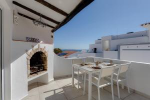 a white table and chairs on a balcony with a fireplace at Casa Alma - V027 in Lagos
