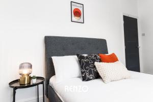 um quarto com uma cama branca com almofadas e um candeeiro em Charming 2-bed Apartment in Nottingham by Renzo, Modern Design, Brilliant Location em Nottingham