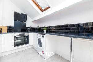 a white kitchen with a washer and dryer at Charming 2-bed Apartment in Nottingham by Renzo, Modern Design, Brilliant Location in Nottingham