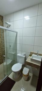 een badkamer met een toilet, een douche en een wastafel bij casa confortável in Camaçari