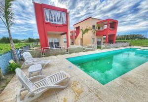 uma casa com piscina em frente a uma casa em Antares em Dolores