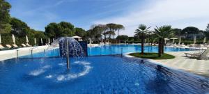 a swimming pool with a water fountain in the middle at Large Apartment - Perla Resort, Gjiri i Lalezit in Draç