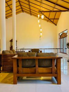 a wooden bench in a large room with chairs at Fortress Gate Bungalow in Polonnaruwa