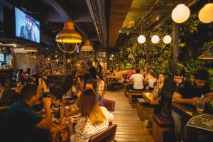 a group of people sitting in a bar at Hotel El Peñon by Bithotels in Cali