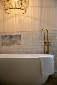 a bathroom with a bath tub and a chandelier at Remarkable 4-Bed House Near Leeds Airport in Yeadon