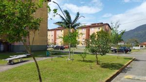 a park with a bench and trees and buildings at Doce Lar in Peruíbe