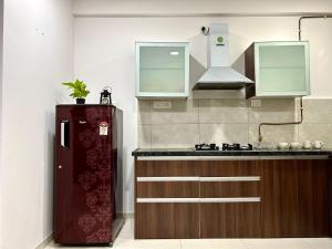 a kitchen with a sink and a refrigerator at BREEZE: By Aryavarta (King-sized 2 BHK apartment) in Pune