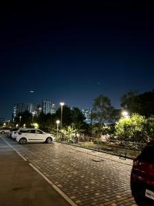 a white car parked in a parking lot at night at BREEZE: By Aryavarta (King-sized 2 BHK apartment) in Pune