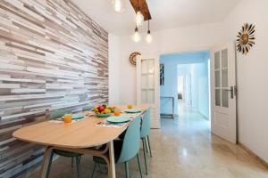 ein Esszimmer mit einem Holztisch und blauen Stühlen in der Unterkunft The 1st Corner Central Apartments in Málaga