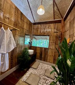 La salle de bains est pourvue de murs en bois, d'un lavabo et de toilettes. dans l'établissement Wanna’s house, à Ban Huai Khai