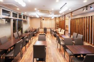 大阪市にあるPearl Spring116 hotelの木製のテーブルと椅子が備わるレストラン