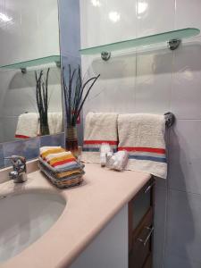 La salle de bains est pourvue d'un lavabo et de serviettes sur un comptoir. dans l'établissement Charming House Nola, 