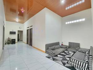 a lobby with two couches and a television in a building at Villa Cisarua Ananda in Brujul