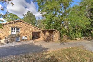 a stone house with a garage in the woods at Les Juliannes - Gîte La Pierre Etoilée Piscine Jardin in Paulinet