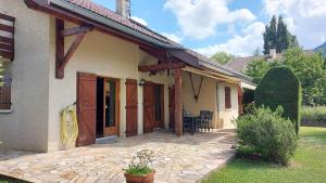 ein Haus mit Holztüren und einer Terrasse in der Unterkunft Le PRINTEMPS Grande villa familiale 10 pers in Annecy