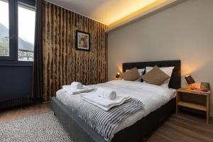 a bedroom with a large bed with towels on it at Beautiful cosy, modern studio in Chamonix centre in Chamonix-Mont-Blanc