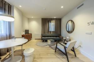 ein Wohnzimmer mit einem Tisch und einem Sofa in der Unterkunft AmazINN Places Palacio Real in Madrid