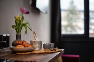 a table with a bowl of bread and a plate of croissants at Beautiful cosy, modern studio in Chamonix centre in Chamonix-Mont-Blanc