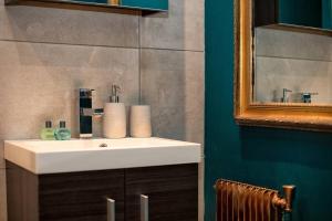 a bathroom with a white sink and a mirror at Beautiful cosy, modern studio in Chamonix centre in Chamonix-Mont-Blanc +2 photos