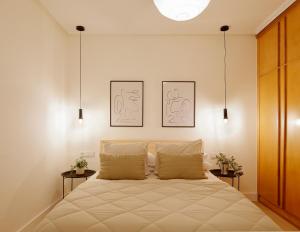 um quarto com uma cama com duas fotografias na parede em Emilio Tuya 60 em Gijón