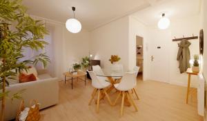 a living room with a table and white chairs at Emilio Tuya 60 in Gijón