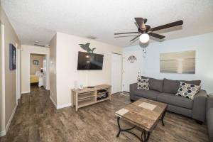 uma sala de estar com um sofá e uma ventoinha de tecto em Tropical Indian Rocks Beach Suite A em Clearwater Beach
