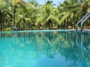 una gran piscina con palmeras en el fondo en Lavendish Wild Wilpattu, en Nochchiyagama