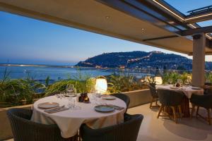 a restaurant with tables and chairs with a view of the ocean at Büyük Hotel in Alanya