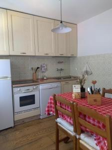 a kitchen with white appliances and a table with a tablecloth at Relax a Cortina d'Ampezzo - Alverà in Cortina dʼAmpezzo