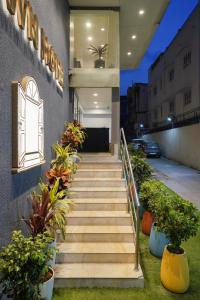 una escalera que conduce a un edificio con plantas en Uptown Hotel en Nagpur