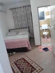 Hotel Beso في Këlcyrë: غرفة نوم بسرير وحمام مع مرآة