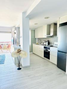 a kitchen with white cabinets and a table in it at Puerta al Mediterráneo in Jávea