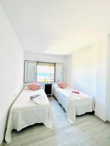 a room with two beds and a window at Puerta al Mediterráneo in Jávea